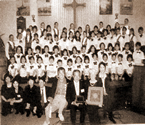 写真をクリックすると新聞記事へ。写真説明=アーカディ音楽祭で共演した米国の子どもたちとまつぼっくり少年少女合唱団 ら。最前列右端が同合唱団の荒井敦子主宰、右から4人目が筆者